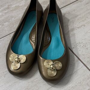 bronze metallic ballet flats with gold medallion …new
Size 7..oka b